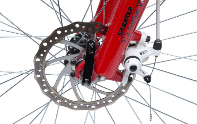 Якщо у вас на велосипеді варто дискові гальма механічного типу (до гідравліки підхід дещо інший), то прибрати зазор, а точніше - усунути деяку кривизну гальмівних колодок, можна правильно закріпивши калипер